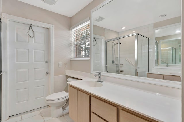 bathroom with tile patterned floors, toilet, vanity, and walk in shower