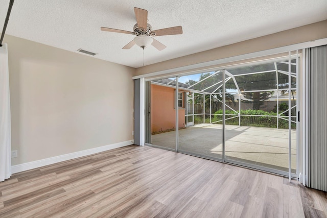 interior space with a textured ceiling, light wood-type flooring, and ceiling fan