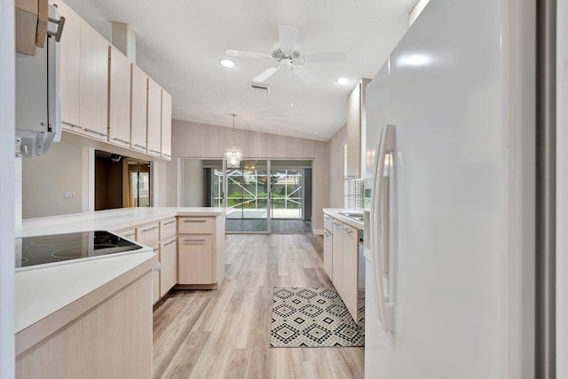 kitchen with lofted ceiling, black electric stovetop, white refrigerator, light hardwood / wood-style flooring, and decorative light fixtures