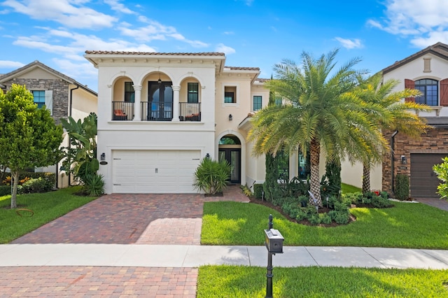 mediterranean / spanish home featuring a balcony, a front yard, and a garage