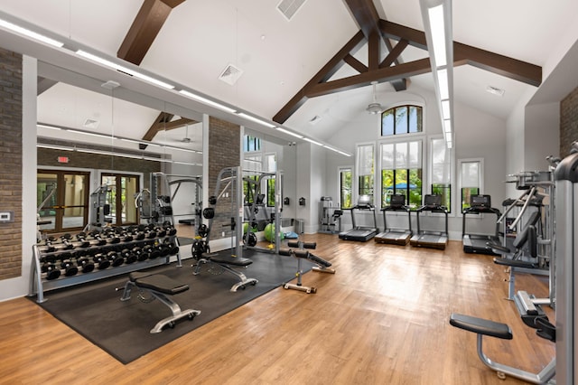 workout area with wood-type flooring and high vaulted ceiling