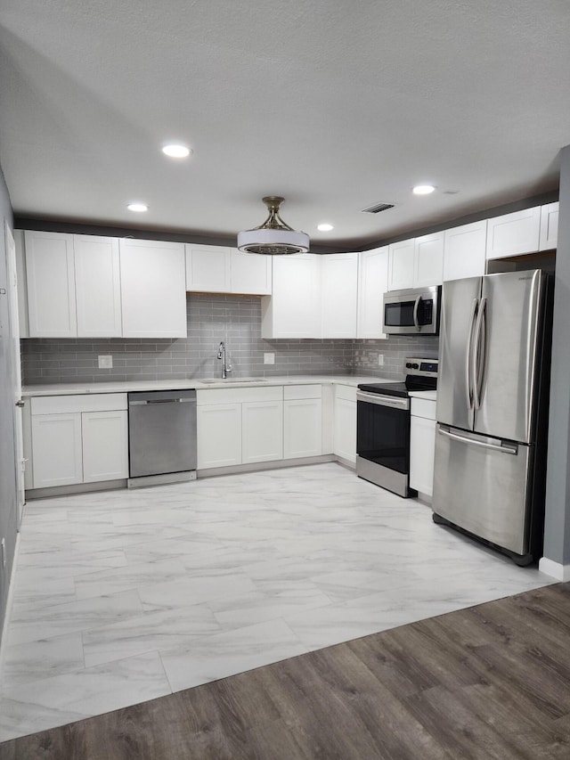 kitchen with sink, stainless steel appliances, and white cabinetry