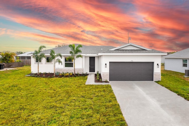 single story home featuring a yard, central AC, and a garage