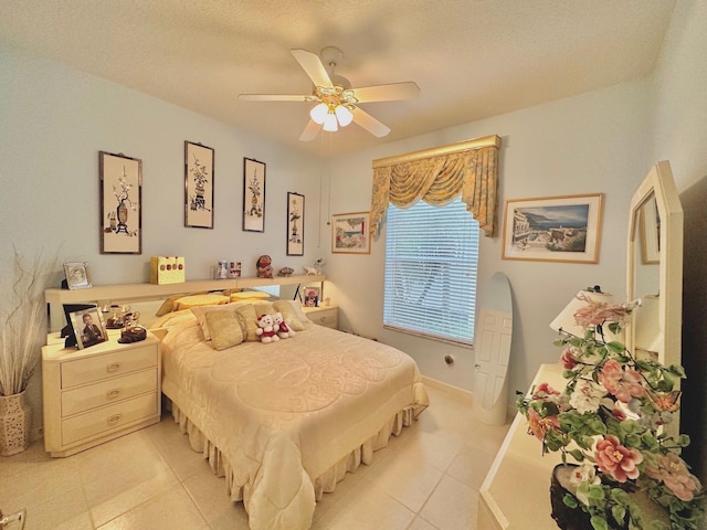 bedroom with a textured ceiling, ceiling fan, and light tile patterned flooring