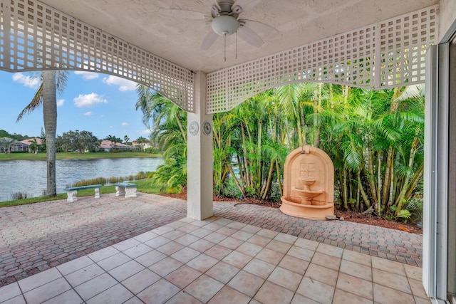 view of patio / terrace featuring ceiling fan and a water view