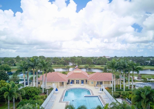 view of pool featuring a water view and a patio