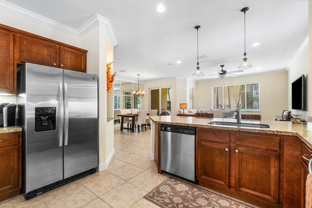 kitchen featuring sink, hanging light fixtures, stainless steel appliances, and ornamental molding