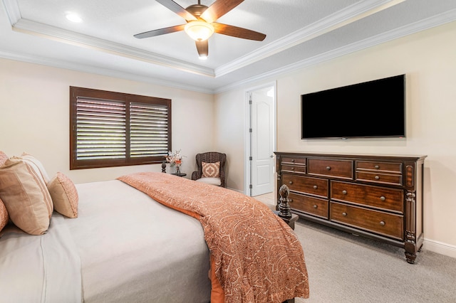 carpeted bedroom featuring ornamental molding, ceiling fan, and a raised ceiling