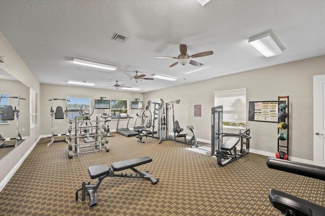 exercise room featuring carpet, ceiling fan, a wealth of natural light, and a textured ceiling