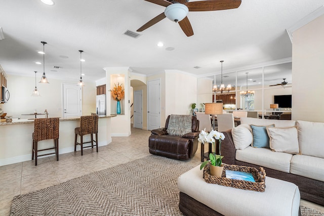 living room featuring ornamental molding, ceiling fan with notable chandelier, and light tile patterned floors