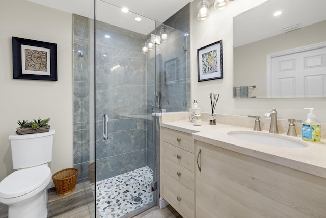 bathroom with an enclosed shower, vanity, and toilet