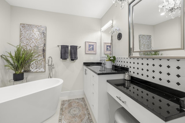 bathroom featuring vanity, a bathing tub, a notable chandelier, and decorative backsplash