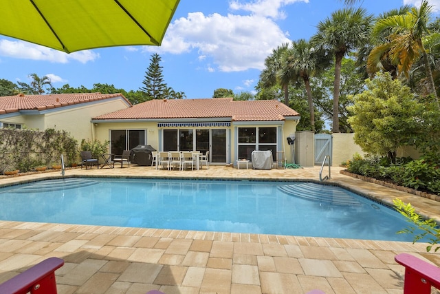 view of swimming pool featuring area for grilling and a patio