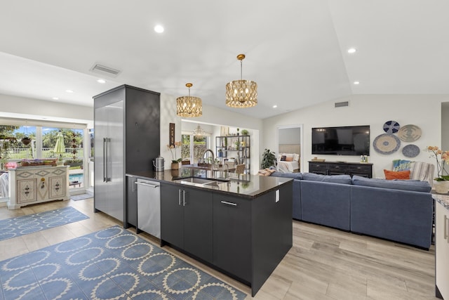 kitchen with lofted ceiling, sink, an inviting chandelier, stainless steel dishwasher, and pendant lighting