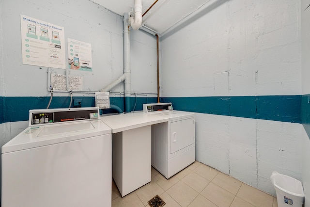 washroom with light tile patterned flooring and washer and dryer