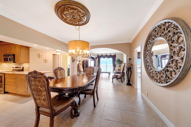 dining room with light tile patterned flooring, an inviting chandelier, and ornamental molding