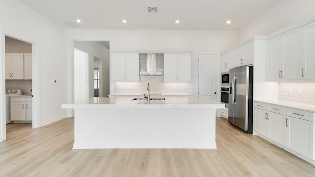 kitchen with light hardwood / wood-style flooring, white cabinets, a kitchen island with sink, and stainless steel appliances