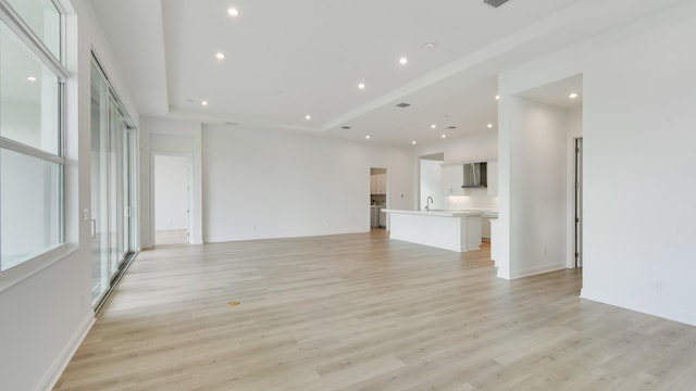 unfurnished living room featuring sink and light wood-type flooring