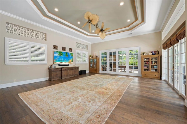 living room with dark hardwood / wood-style floors, french doors, crown molding, and a tray ceiling