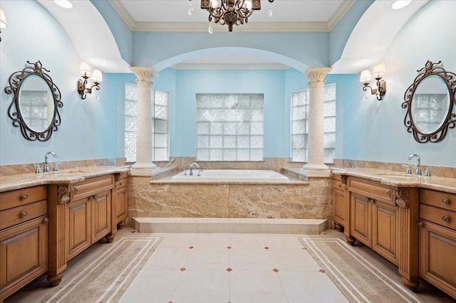 bathroom featuring ornate columns, a chandelier, tiled tub, and ornamental molding