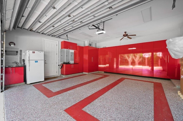 garage featuring ceiling fan, white fridge, and a garage door opener