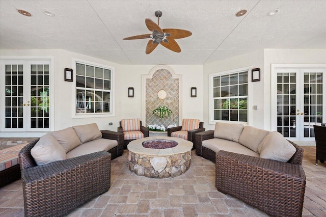 view of patio / terrace with ceiling fan, french doors, and an outdoor living space with a fire pit