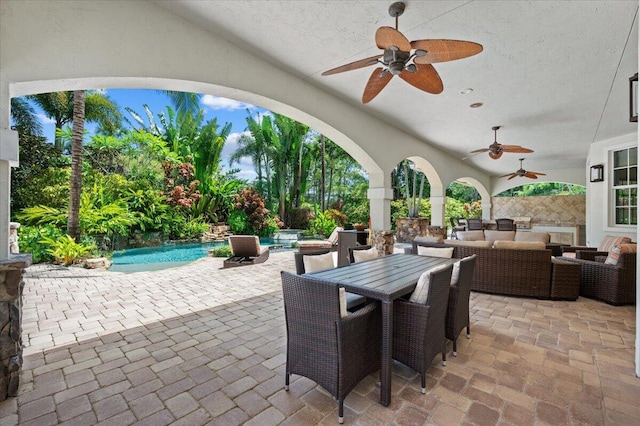 view of patio / terrace with outdoor lounge area, ceiling fan, and a pool with hot tub