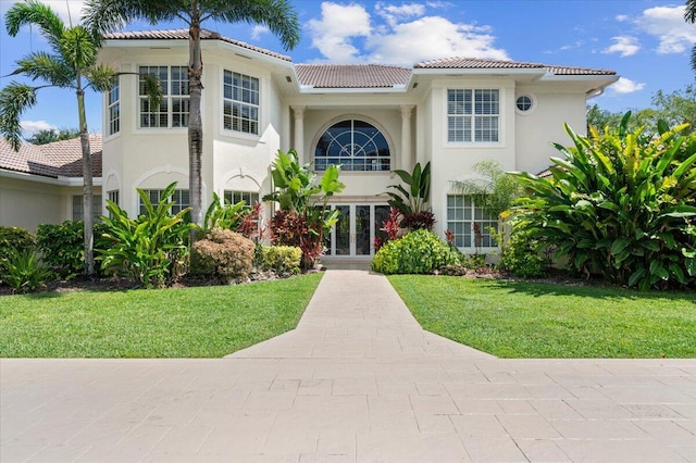 mediterranean / spanish-style home with french doors and a front lawn