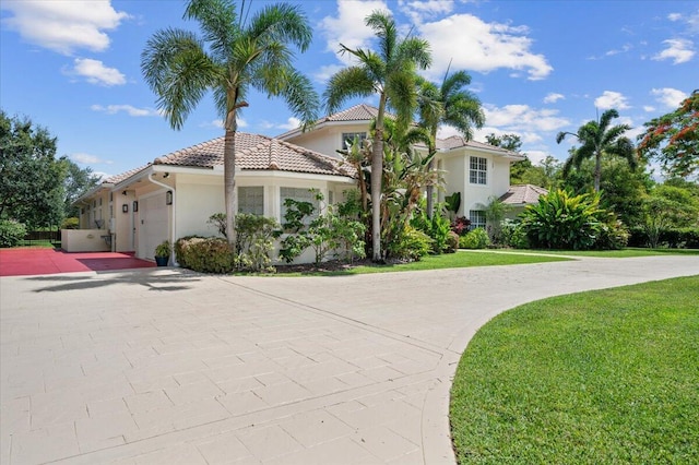 mediterranean / spanish-style home with a front yard and a garage