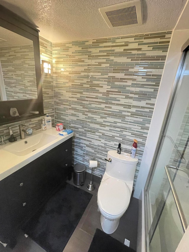 bathroom with tasteful backsplash, an enclosed shower, vanity, tile walls, and tile patterned flooring