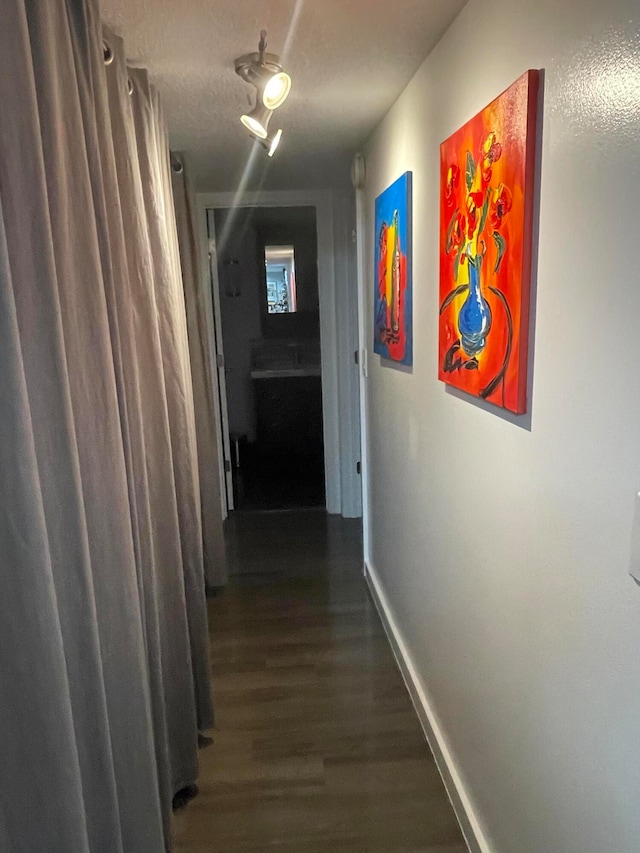 corridor featuring hardwood / wood-style floors and a textured ceiling