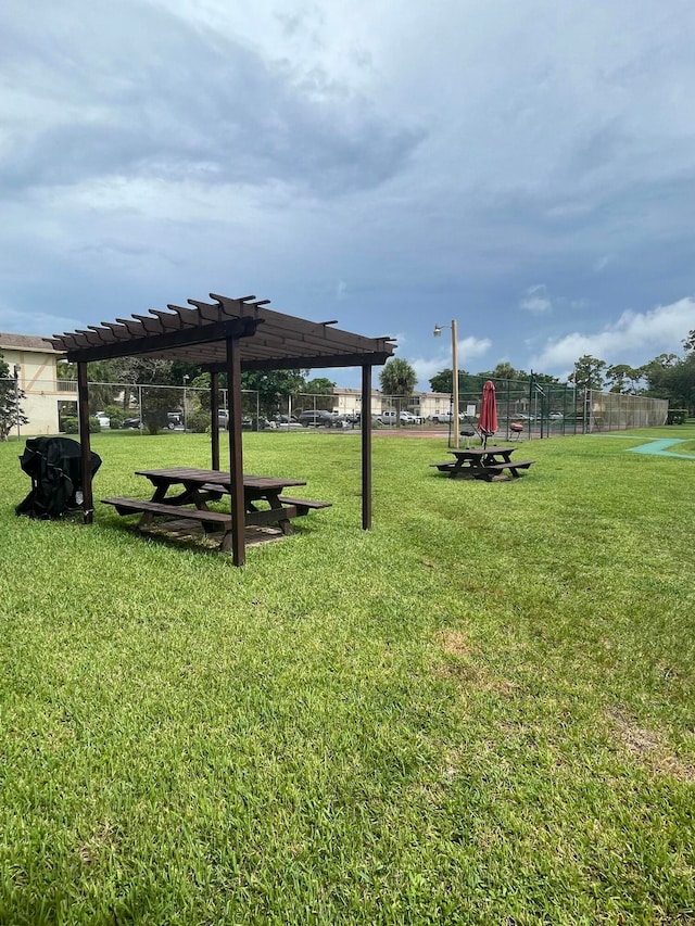 view of home's community featuring a pergola and a yard