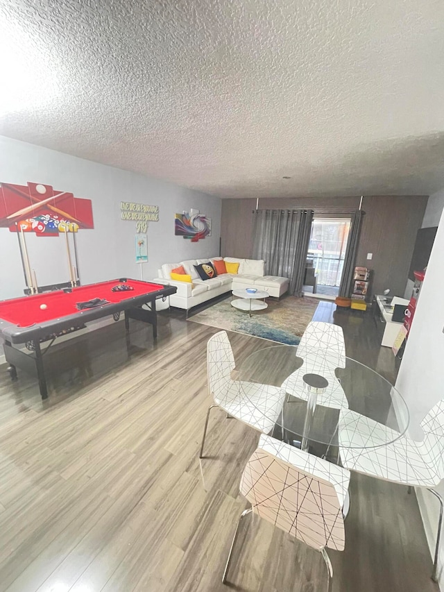 living room with hardwood / wood-style floors, a textured ceiling, and billiards