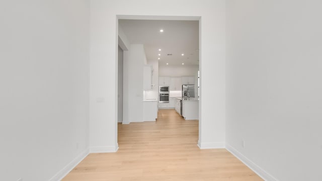 corridor with light hardwood / wood-style flooring