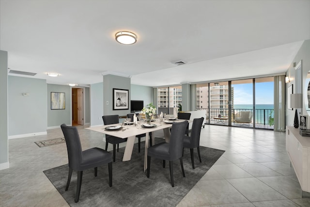 dining area featuring a wall of windows and light tile patterned floors