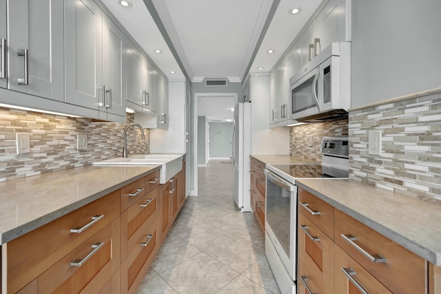 kitchen with sink, white appliances, backsplash, and white cabinets