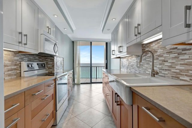 kitchen with white cabinetry, tasteful backsplash, light tile patterned floors, a wall of windows, and white range with electric stovetop