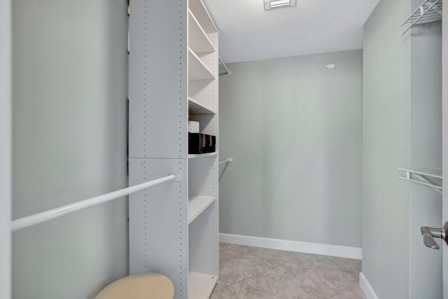 walk in closet featuring light tile patterned flooring