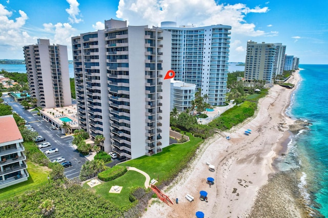 drone / aerial view with a view of city, a water view, and a view of the beach