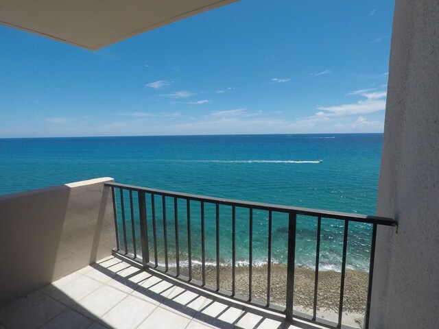 balcony featuring a view of the beach and a water view