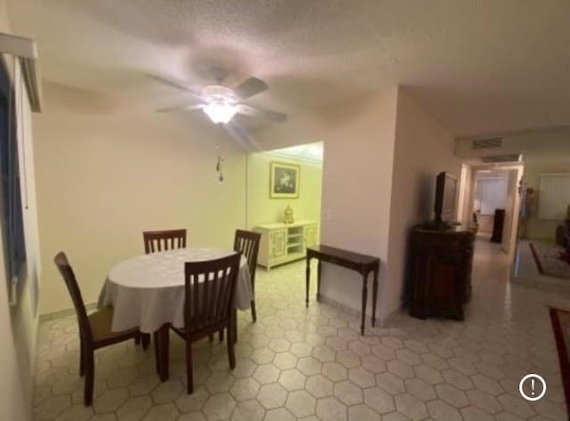 tiled dining space with ceiling fan