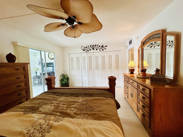 tiled bedroom with ceiling fan, a closet, and a textured ceiling