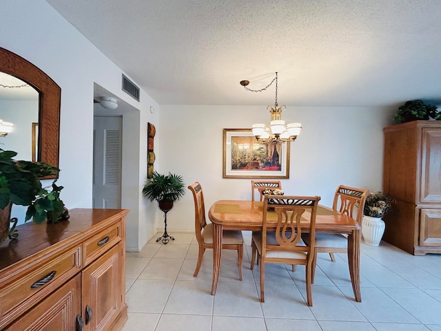 dining space with light tile patterned floors, a textured ceiling, and an inviting chandelier