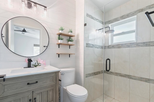 bathroom featuring tile walls, toilet, vanity, and ceiling fan