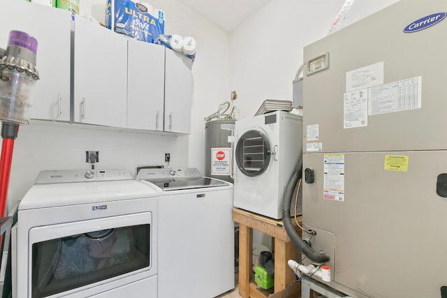 laundry room featuring independent washer and dryer, heating unit, cabinets, and water heater