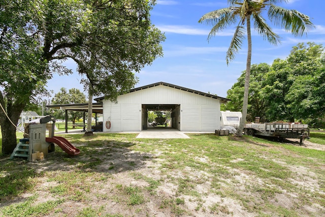 rear view of property with a yard, a playground, and an outdoor structure