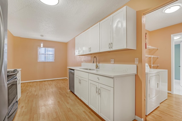 kitchen with white cabinets, independent washer and dryer, hanging light fixtures, and sink