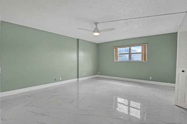 spare room featuring a textured ceiling and ceiling fan