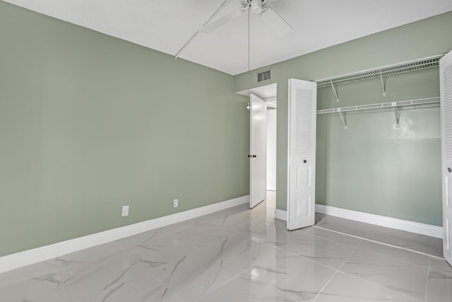 unfurnished bedroom with ceiling fan and a closet