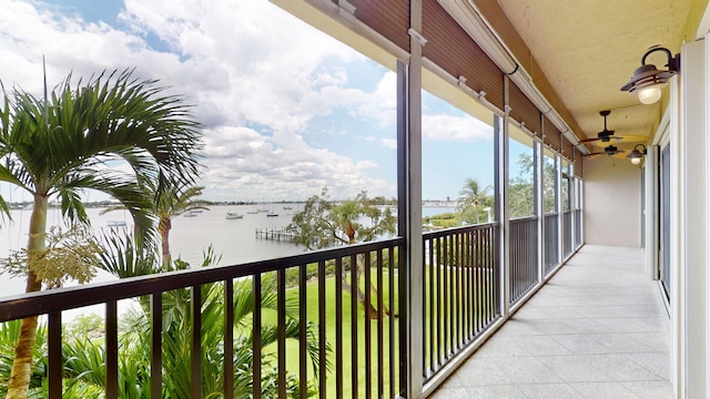 balcony with a water view and ceiling fan